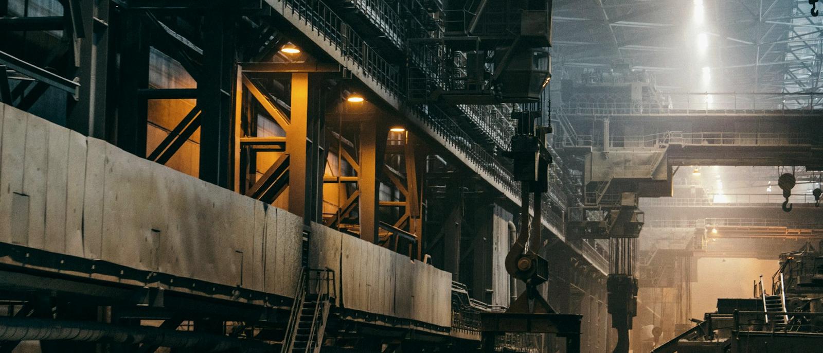 Heavy industrial process plant interior with structural steel and pipework
