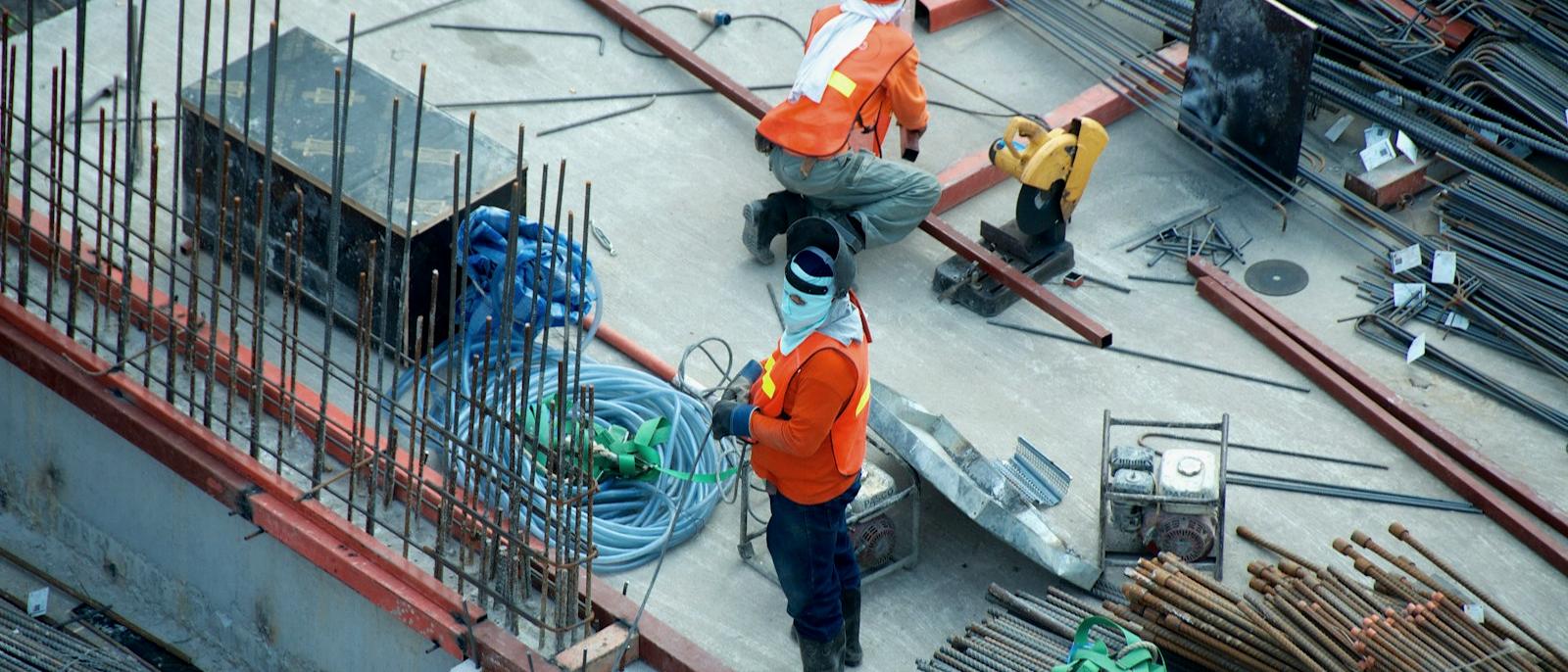 Aerial view of technical crews working on an industrial construction deck